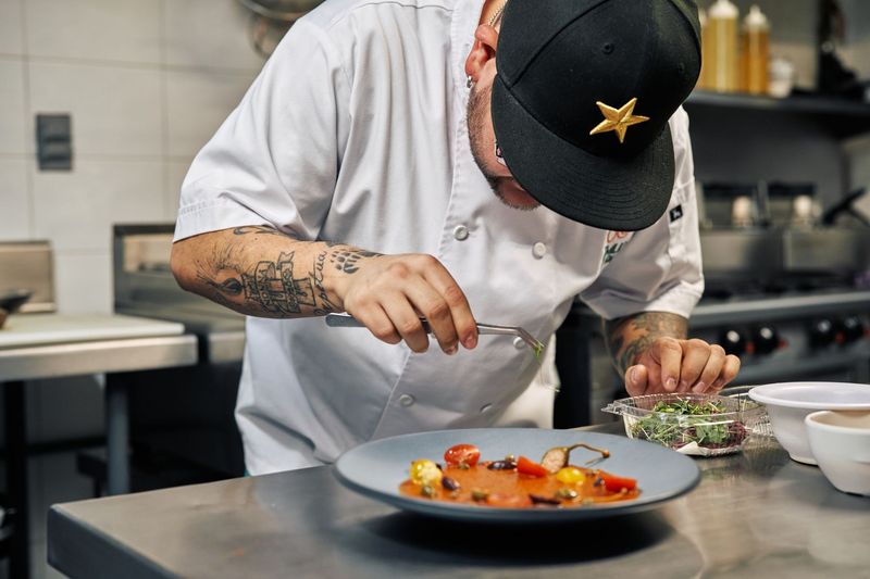 Private chef quietly resetting a luxury home kitchen after dinner service