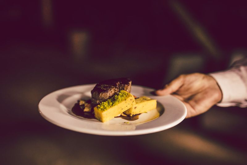 Chef finishing a refined entrée with precise detail
